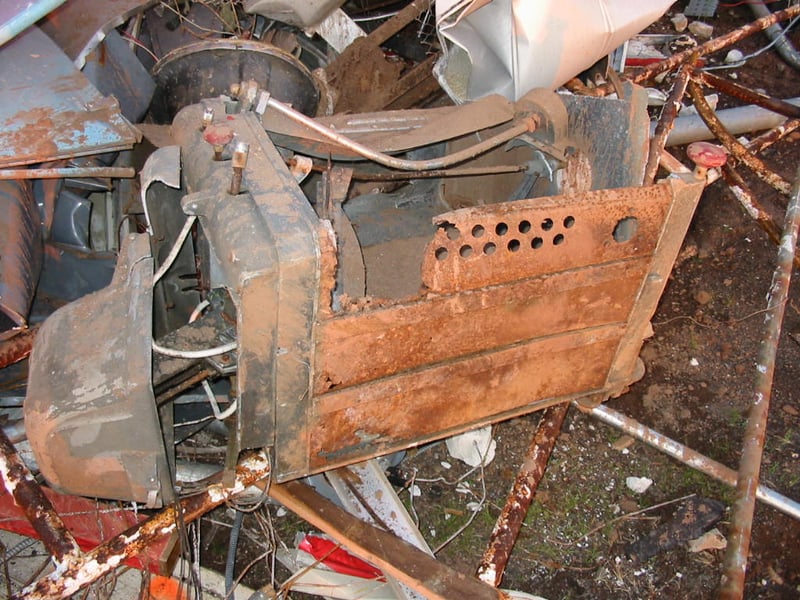 The bashed arc lamp sitting in the trash pile.