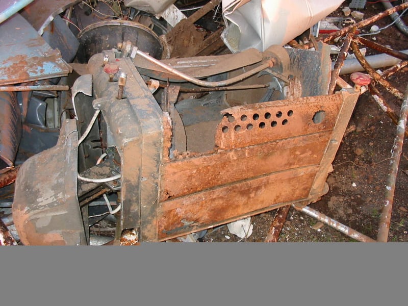 The bashed arc lamp sitting in the trash pile.