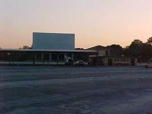 Screen, main building, and car ports at sunset