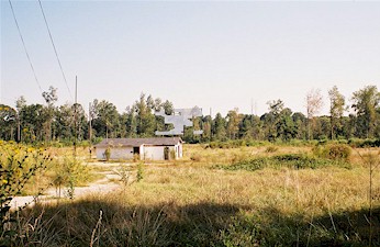 Field with projection/concession building and screen tower. Very poor condition of screen if this drive-in did indeed close 2 years ago. Field still has speaker posts.