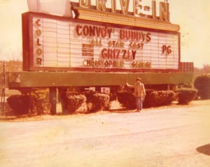 Photo of me Tommy Holcombe standing with the marquee at the Glenwood Drive-In from early 1978.