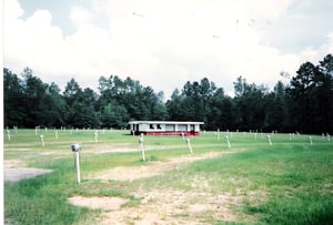 Field with poles and speakers, concession/projection building.