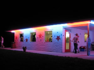 Photo of the concession stand building, illuminated by the neon lights.