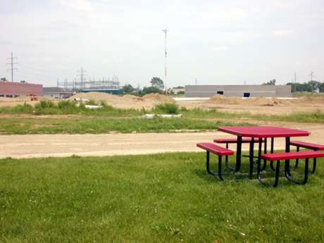 Dairy Queen picnic table with the site of the former drive-in behind it.
