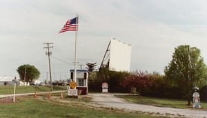 Entrance to Harvest Moon showing  the screen and ticket booth.  Traffic lights govern traffic purchasing tickets from either side of ticket booth.