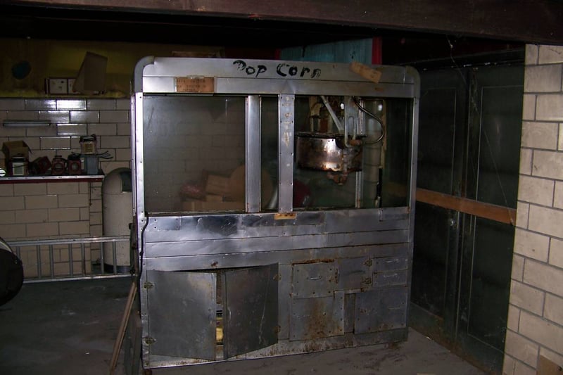 Old popcorn machine in boarded up snackbar of the outdoor theater.