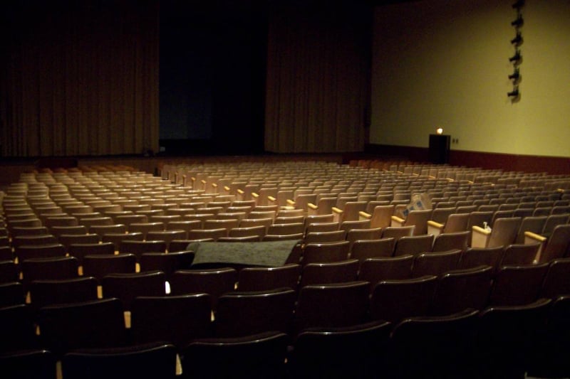 Auditorium of indoor theater on the property.  Movie screen is behind the gold curtains.
