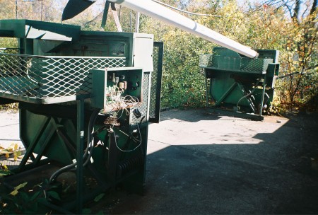 Pitching machines in the batting cage next to the screen.