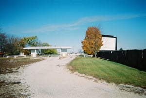 Entry road with ticket booths and screen in the distance.