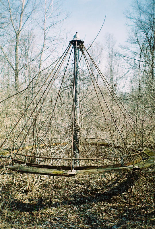 Some sort of a kiddie ride; the only ride left on the overgrown playground in front of the screen.