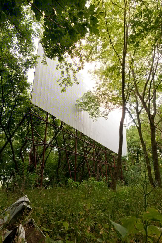 The thick overgrown trees and other vegetation made it hard to locate the screen. I pulled out the Google Maps app on my phone and turned on realtime GPS and satellite view. Then I was able to finally find the camouflaged screen