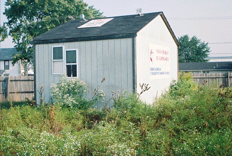 Only building remaining...used during flea markets. Sign on side says "future site of Korean Methodist church."