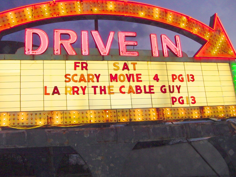 As seen from the driver's seat, driving a '68 Pontiac GTO up to the ticket window near dusk.