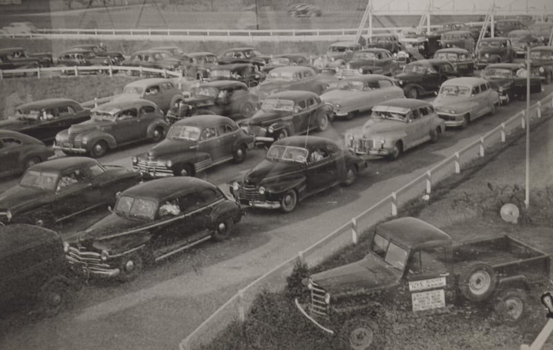 Cars arriveing at the drive-in.