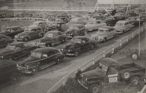 Cars arriveing at the drive-in.