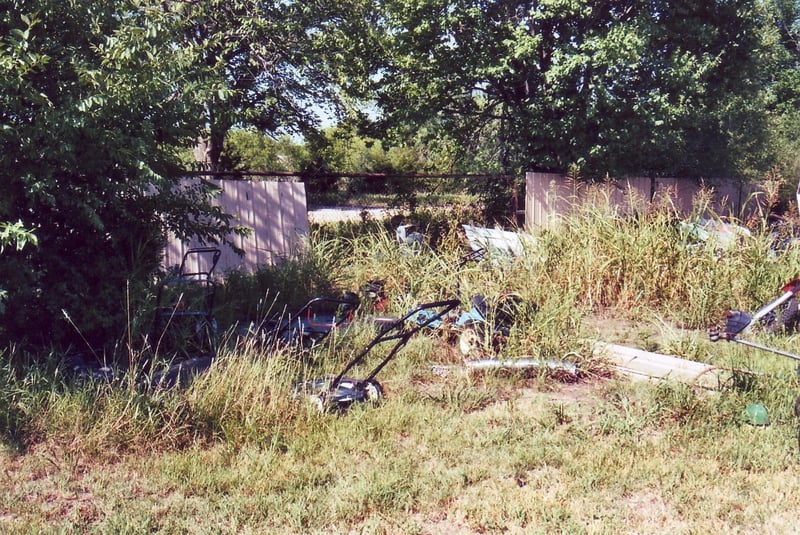 Parts of old perimeter fence behind the lawn mower repair shop