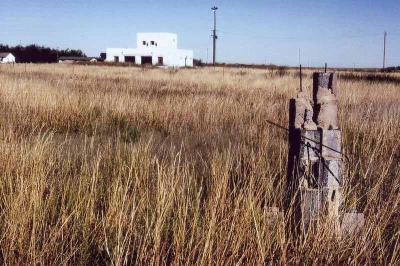 Empty, grassy field with projection/concession building