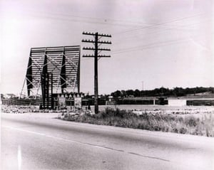 50s black + white pic of screen tower, marquee, ticket booth, entranceway, + lot