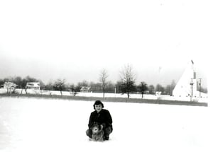 Picture of Margie Simms Gibson in the snow w/drive-in in the background.