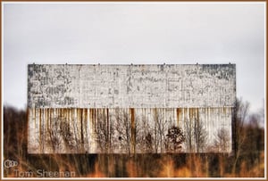The screen of the abandoned Braintree Twin Drive-in in Braintree, Massachusetts. The grounds are now used for public commuter parking.