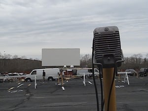Speaker with screen in the background during an early spring flea market