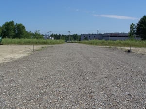 Gravel road that cuts through the middle of the former lot.