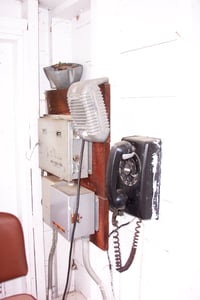 Phone, speaker and lighting timers on box office wall.