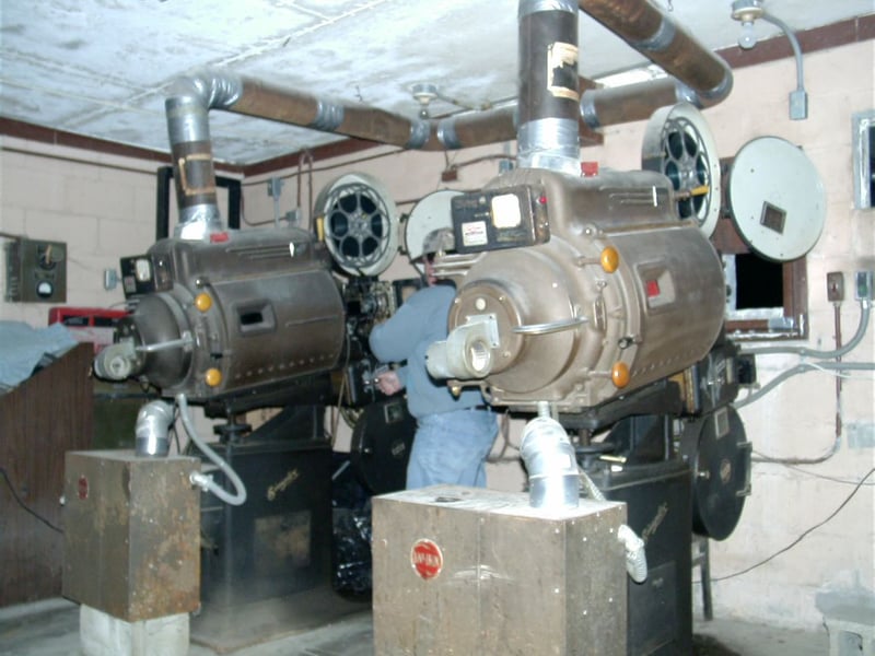 Projectionist Dan Arnold makes adjustments on one of 35 millimeter film projectors.