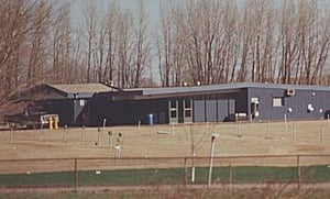 view of lot, speaker poles, + projection/concession stand building