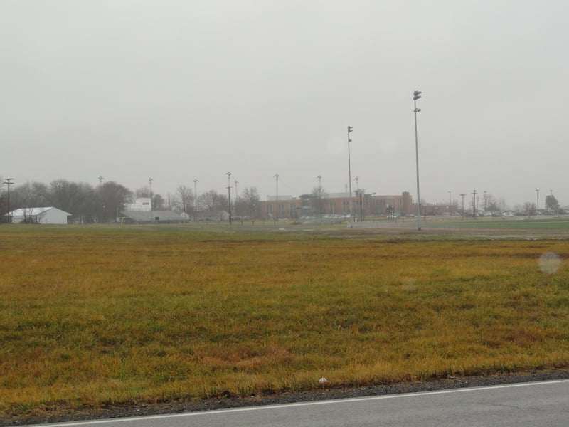 now an empty field behind the high school track on the east side of BR-71
