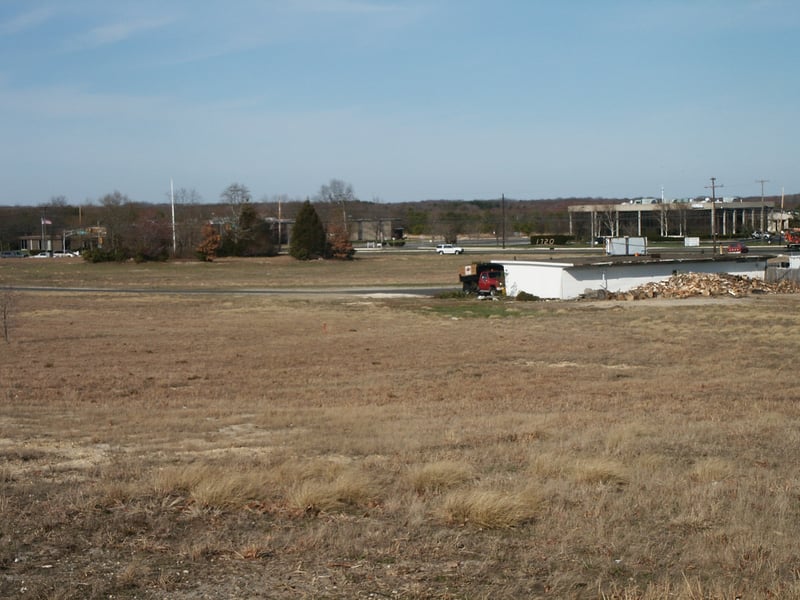 View towards where screen once stood. Flag pole on left side of picture is exactly where screen used to be. Overgrown bushes that used to be directly under the screen, and in front of long gone playground are still there. All parking rows must have been l