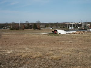 View towards where screen once stood. Flag pole on left side of picture is exactly where screen used to be. Overgrown bushes that used to be directly under the screen, and in front of long gone playground are still there. All parking rows must have been l