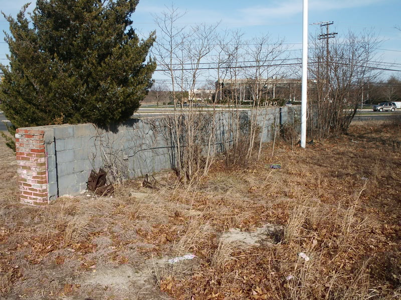 Screen tower rear anchor foundation supports. A brick facade with a flag pole covers these supports from the street.
