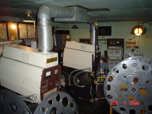 This is the projection room with a reel system call a "mutt." It allows you to fit the whole movie on one reel, and only one projector is necessary. Unlike a platter, the projectionist must use a motorized rewind to rewind the film.