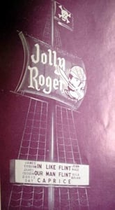 Boxoffice mag; Towering "sail" sign fortells pirate ship decor of Levin Theatres' new 1,600 car Jolly Roger Drive-In, in Sharonville, OH. employees wear pirate costumes, eye patches. Boxoffice is 65-ft high Caribbean sea fort. Entranceway is called "gangp