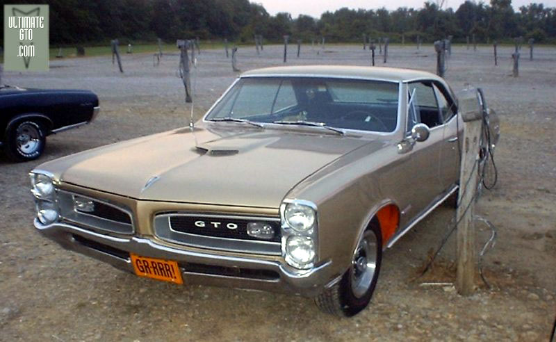 Kingman Drive-In, Delaware Ohio
GTOAA club meet event 7/7/2000
'66 GTO hardtop gold with red fenders next to a movie speaker at 
the Kingman Drive-In. Sharp photo! This one would make a neat computer
wallpaper image.