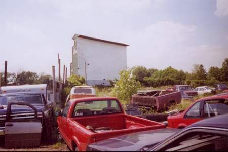 Screen and lot filled with junk cars