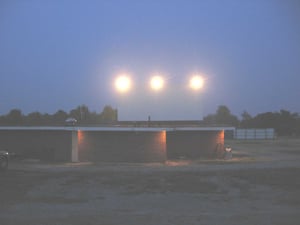 Concession building and screen with lights on during intermission.