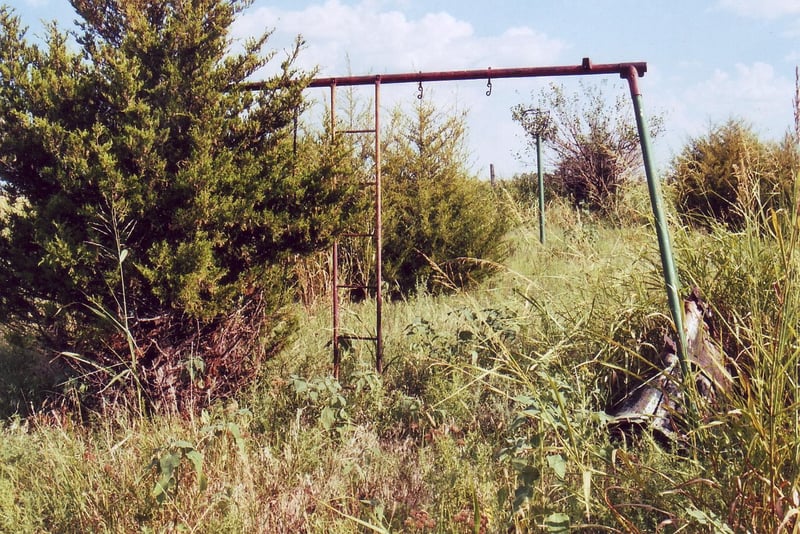 The rusty frame of the swings is still present