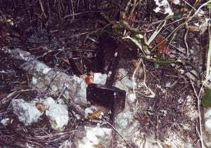 Short remaining steel stump of the screen tower found in the weeds which have grown in this area