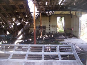 Half of the wooden roof of the snack bar has collapsed. In the wooden frame next to the opening at right, obviously used to hang a mirror