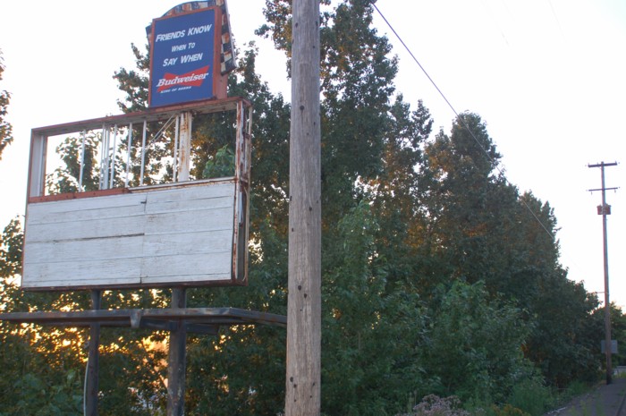 Old marquee with what appears to be the screening trees in the background. Looking North with the highway on the right.