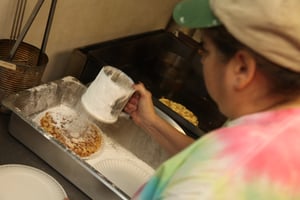 Joan Deppe, powdering the fresh funnel cakes made at Becky's Drive-In nightly