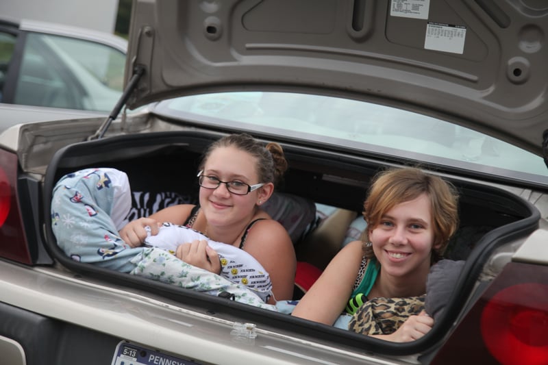 girls sit in the trunk of their car to watch the double features