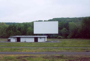 Field, screen, and projection/concession building taken from last parking row.