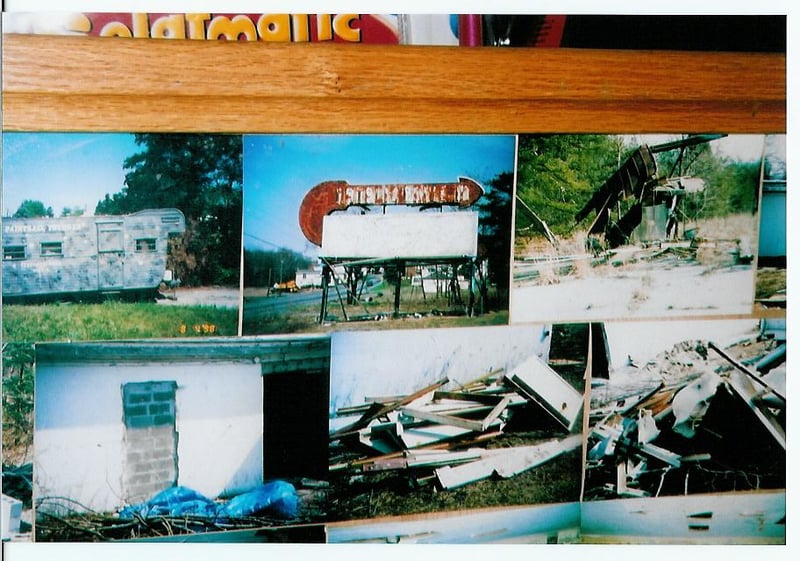 A bulletin board with photos of the drive-in. The grounds are utilized as a paintball course.
