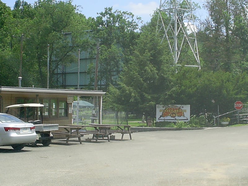 Back of screen hidden by trees as seen from swimming pool parking lot