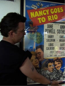 Hanging the Nancy Goes to Rio poster in concession stand. Nancy Goes to Rio was the first movie shown at the Big Mo.