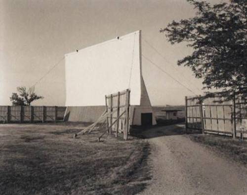 black + white pic of field, screen, fence, and exit(ticket booth can also be seen between the fence and screen) (from carlweese.com)