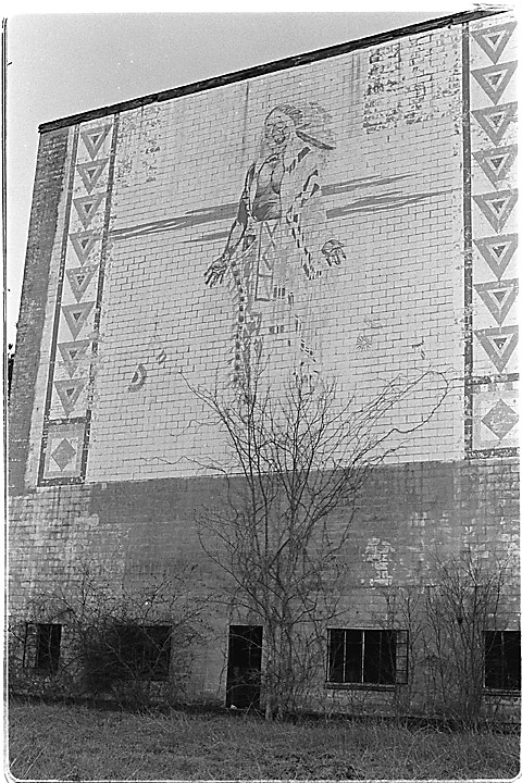 Exterior facing road. Approx 30 years after closing. Landmark structure and its weathered mural has since been demolished.